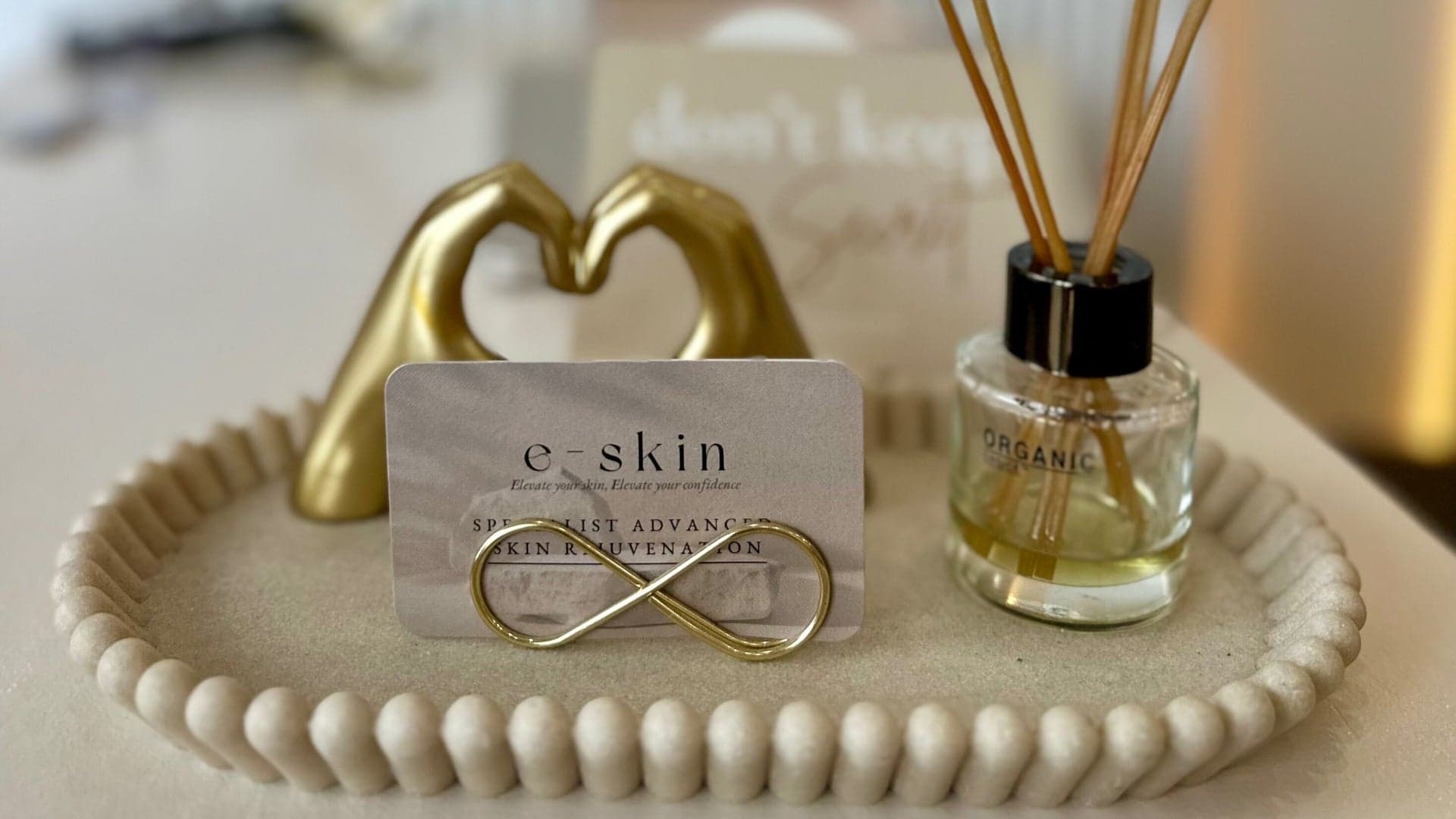 Decor detail at e-skin with a golden heart and organic diffuser