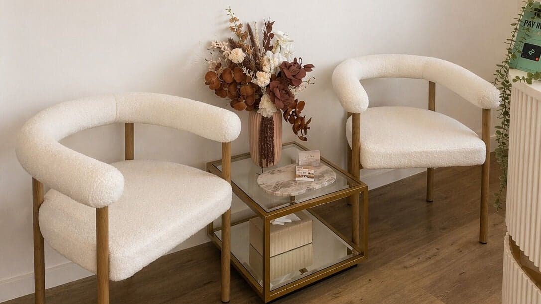 The waiting area at e-skin in Southport, with boucle armchairs, gold detailing and dried florals